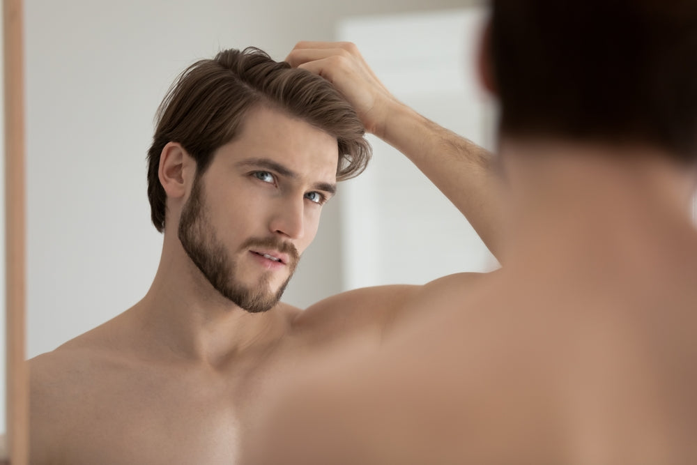 hairmetto, understanding hair loss blog, man looking in mirror examining hairline