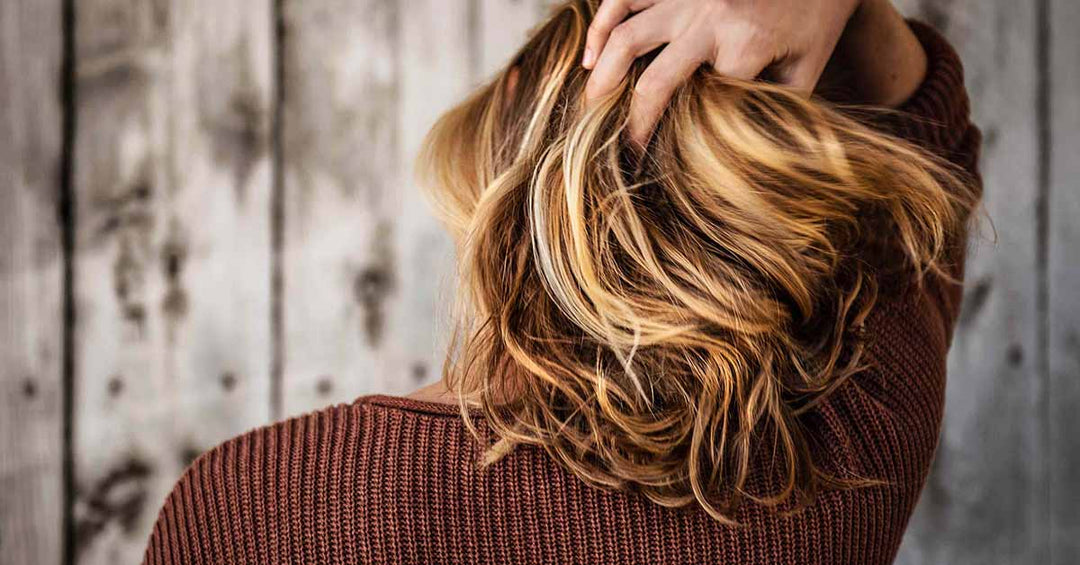 Woman brushing hand through hair. How To Use HAIRMETTO Blog