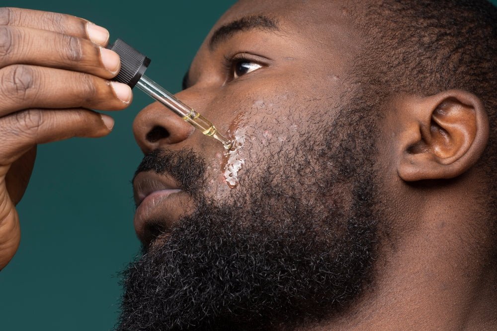 African American man applying facial oil to beard by hairmetto